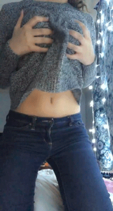 hoisting up her sweater and displaying her boobs